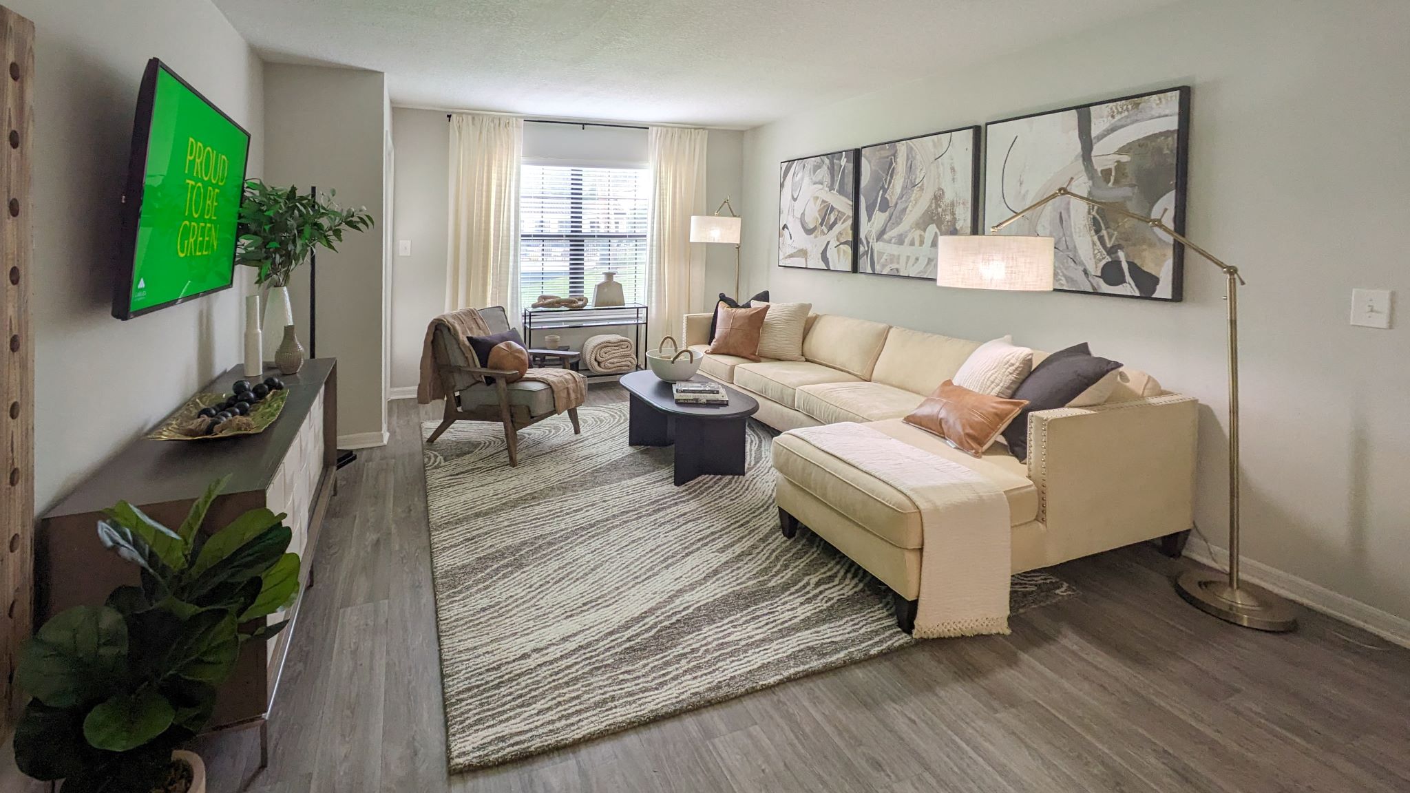 A living room with a white couch and a green sign on the wall.